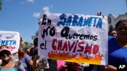 Simpatizantes del líder opositor Freddy Superlano, sostienen una pancarta con un mensaje que dice en español: "En Sabaneta no queremos el chavismo", en referencia a la política del fallecido presidente Hugo Chávez, durante una protesta en Barinas, Venezuela. Diciembre 4 de 2021.