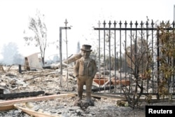 A statue stands among the remains of a home destroyed by the Tubbs Fire in Santa Rosa, Calif., Oct. 10, 2017.