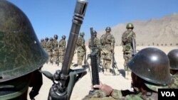 FILE - Afghan soldiers train with their weapons at the Kabul Military Training Center on the outskirts of the Afghan capital.