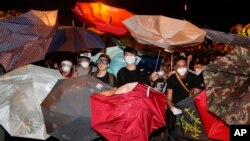 15일 홍콩 정부 청사 앞에서 시위대가 경찰이 발사한 최루액을 우산으로 막고 있다.
