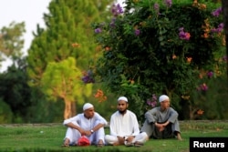 Students from a local madrassa rest on the lawn near a traffic light in Islamabad, Pakistan July 14, 2017.