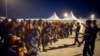 A group of migrants react in front of Spanish Police officers at the port of Algeciras, southern Spain, after being rescued by Spain's Maritime Rescue Service in the Strait of Gibraltar, July 31, 2018. Spain's foreign minister says the European Union's executive branch has allocated 55 million euros ($64.2 million) to manage an upsurge of migrant arrivals mostly from Morocco.