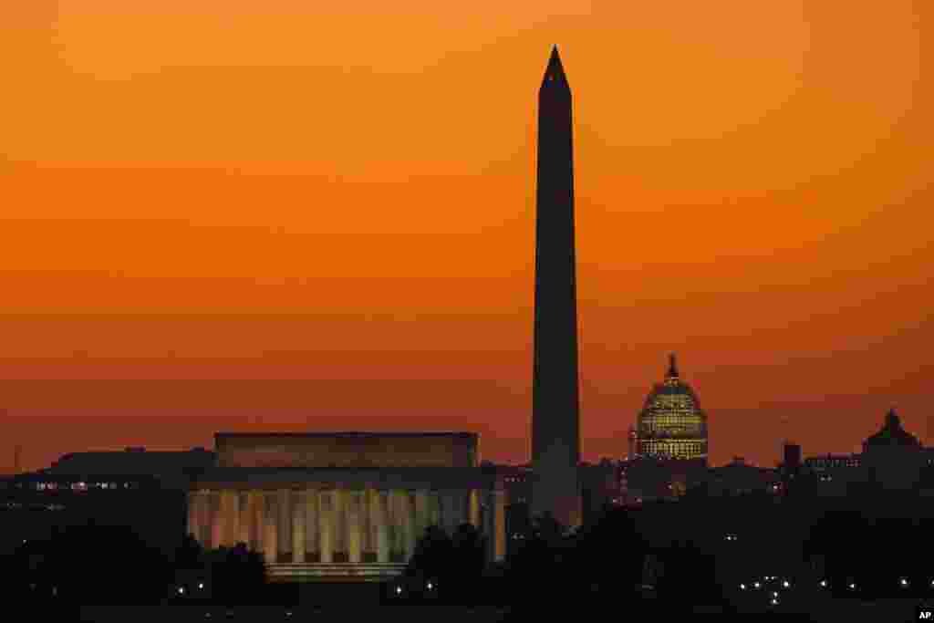 The orange sky of sunrise is captured behind the skyline of Washington on the first day back to work for the U.S. Congress after their summer recess.