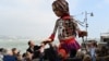 Engleski glumac <strong>Džud Lou</strong> drži ruku &quot;Male Amal&quot;, džinovske lutke koja predstavlja&nbsp;devojčicu izbeglicu iz Sirije, dok se šesta duž obale mora u luci Folkestoun, na jugoistoku Engleske, gde je stigla iz Kalea, u sklopui međunarodnog umetničkog projekta &quot;Šetnja&quot; (The Walk) (Foto: AFP/Glyn Kirk)