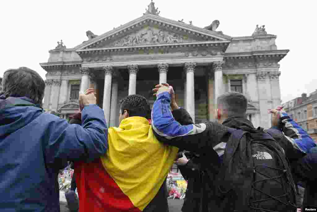 People join hands in solidarity near the former stock exchange following Tuesday's bomb attacks in Brussels, Belgium, March 23, 2016. 