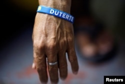 FILE - An inmate who is about to be released wears a wristband with the name of Philippine President Rodrigo Duterte at Quezon City Jail in Manila, Philippines, Oct. 18, 2016.