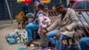 A woman consults a traditional doctor near the Baragwanath taxi rank in Soweto, South Africa, Dec. 2, 2021. Fearing vaccines, some turn to traditional doctors for COVID-19 remedies. 