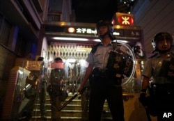Police stand guard outside while police arrest protesters at Prince Edward MTR Station, Hong Kong, Saturday, Aug. 31, 2019.