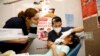 FILE - UT Health Dental School student volunteers provide a free dental screening on a child at Fiesta Mart in Houston, June 13, 2015. 