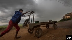 Seorang pedagang kaki lima bergegas pulang ke rumah menjelang badai di Antananarivo, Madagaskar, 9 Desember 2019. Topan Belna telah menghantam Madagaskar utara, menyebabkan 1.400 orang kehilangan tempat tinggal, Selasa (10/12).