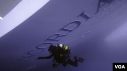 Seorang penyelam Italia tampak memeriksa kapal pesiar Costa Concordia sebelum mulai melakukan pencarian korban yang masih hilang (19/1).