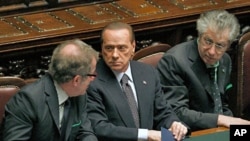 Italian PM Silvio Berlusconi (C) speaks with Justice Minister Roberto Maroni (R) and League North Party leader Umberto Bossi during a finance vote at the parliament in Rome, November 8, 2011