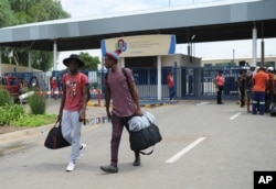 FILE - Students leave the campus at the North-West University in Mahikeng, South Africa, (also known as Mafikeng) Feb. 25, 2016, after protesting students burned down parts of the campus.