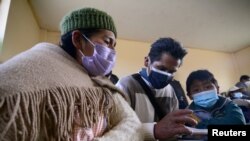 Carlos Gutierrez (R), his mother Angela Poma and his father Lorenzo Gutierrez attend a lesson on how to handle a smartphone for virtual home schooling in El Alto, Bolivia July 12, 2021. REUTERS/Claudia Morales