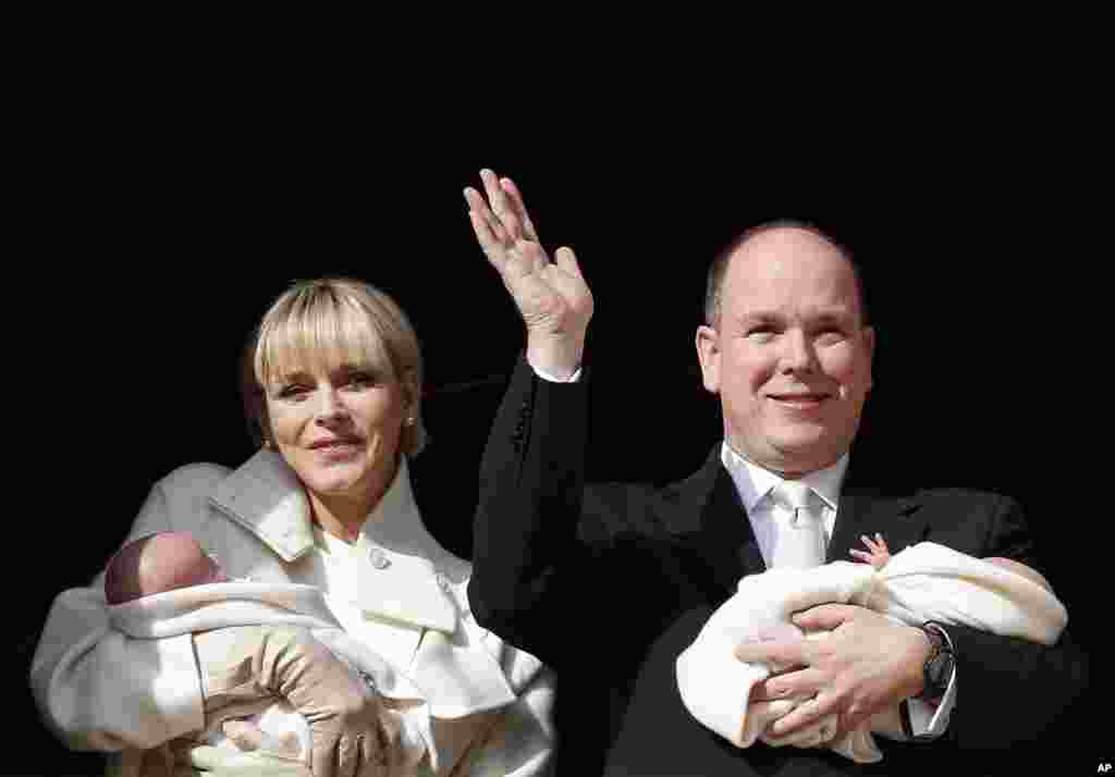 Princess Charlene and Prince Albert of Monaco appear on a palace balcony, each holding a newborn baby swaddled in white. The hereditary heir Prince Jacques and his older sister - by 2 minutes - Gabriella were greeted by a small sea of red-and-white flags and banners.