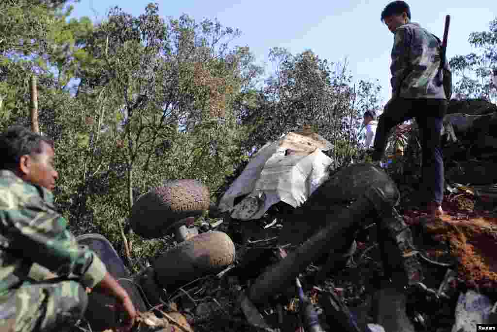 Rescue workers search an air force plane crash site near Nadee village, Xiang Khouang province, Laos, May 17, 2014.