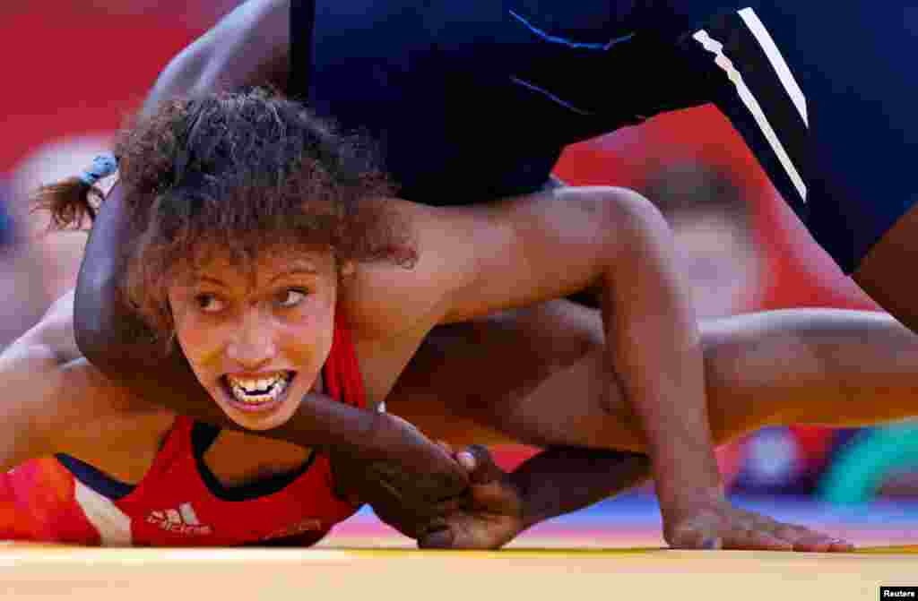 Senegal's Isabelle Sambou (in blue) fights with Tunisia's Maroi Mezien on the repechage of the Women's 48Kg Greco-Roman wrestling. 