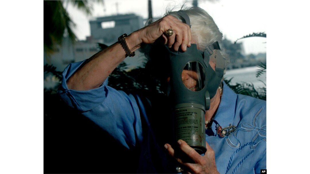 Joan Rodby tries on a gas mask at Arizona Memorial, in Pearl Harbor, Hawaii, Nov., 29, 2007. Rodby is using a mask similar to the one she used as 10-year-old fifth grader at Thomas Jefferson Elementary School in Waikiki.