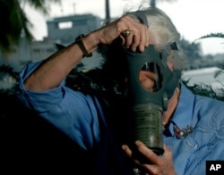Joan Rodby tries on a gas mask at Arizona Memorial, in Pearl Harbor, Hawaii, Nov., 29, 2007. Rodby is using a mask similar to the one she used as 10-year-old fifth grader at Thomas Jefferson Elementary School in Waikiki.