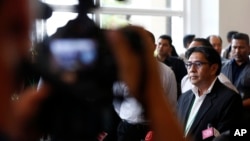 말레이시아 당국자들이 2일 실종 여객기 탑승객 가족들과 비공개 면담한 후, 면담 내용을 설명하기 위해 기자회견장으로 향하고 있다.