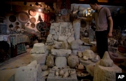 In this July 17, 2019 photo, a Palestinian looks at ancient artifacts displayed inside the Shahwan private museum in the basement of a building, in Khan Younis, Southern Gaza Strip.