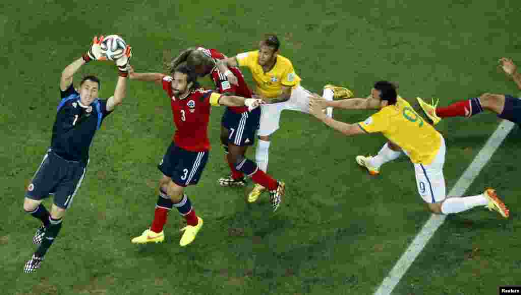 کولمبیا کے گول کیپر ڈیوڈ اوسپینا برازیل کے کھلاڑیوں سے فٹبال کو بچاتے ہوئے