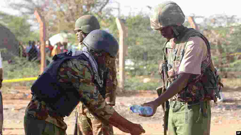 Des militaires kenyans se lavent les mains après avoir transporté un cadavre, à Mandera, au Kenya, le mardi 7 juillet, 2015