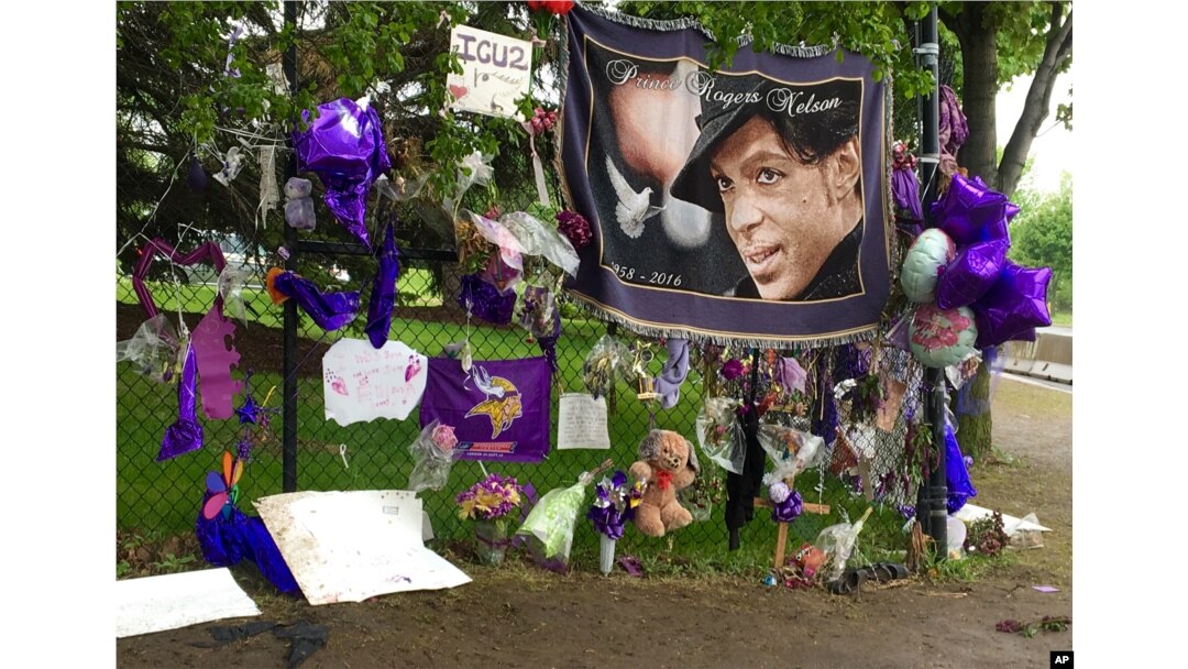 FILE - Items left by fans at a memorial for musician Prince hang from a fence outside Paisley Park, May 11, 2016, in Chanhassen, Minnesota.