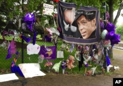 FILE - Items left by fans at a memorial for musician Prince hang from a fence outside Paisley Park, May 11, 2016, in Chanhassen, Minnesota.