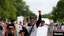 Des manifestants se rassemblent sur les lieux où George Floyd, un homme noir non armé, a été immobilisé par un policier à genoux sur son cou avant de mourir à l'hôpital de Minneapolis, Minnesota, États-Unis, le 26 mai 2020. REUTERS / Eric Miller