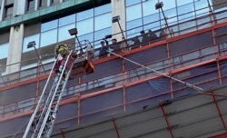 Petugas pemadam kebakaran berupaya menyelamatkan pengunjung yang terjebak kebakaran di atap World Trade Center di distrik perbelanjaan Causeway Bay yang populer di Hong Kong, Rabu, 15 Desember 2021.