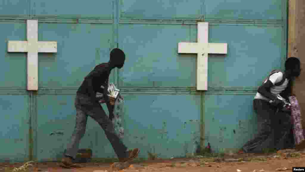 Des passants essaient de s&rsquo;abritent près d&rsquo;une église au cours des combats entre les soldats africains de maintien de paix et les combattants de la milice chrétienne anti-balaka, Bangui, le 18 février 2014. 