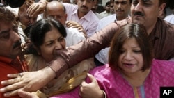 Indian Foreign Service (IFS) officer Madhuri Gupta (R) is escorted after making an appearance at Tis Hazari Court in New Delhi (file photo - 1 May 2010)