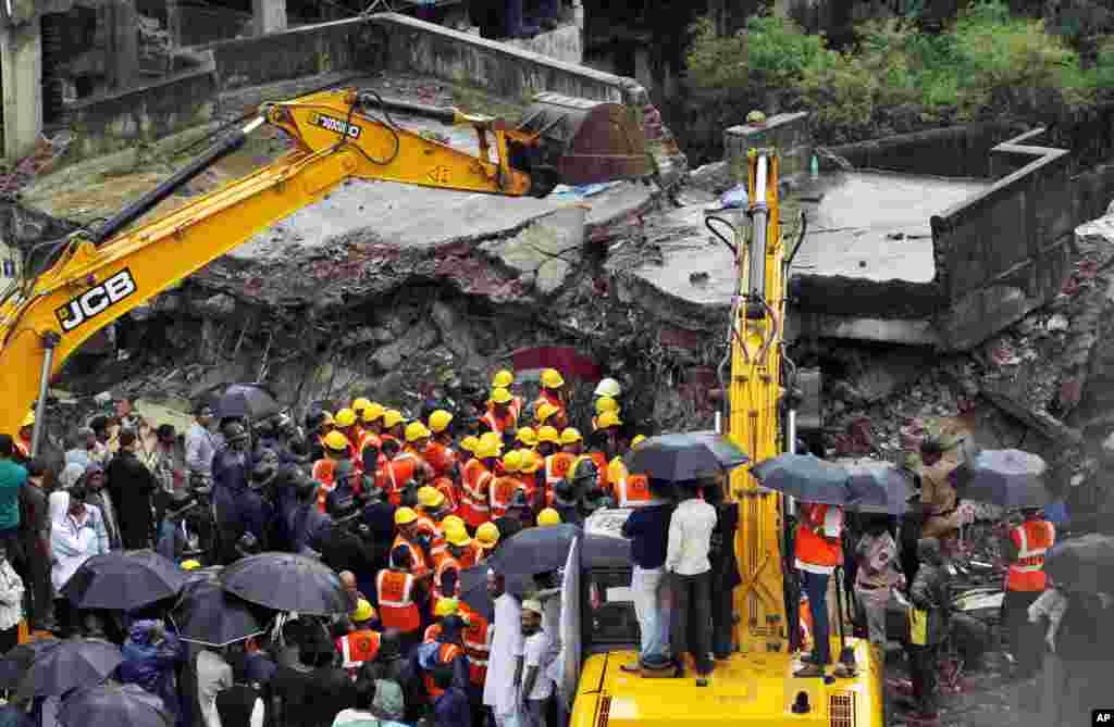 Indian rescue workers look for trapped people after a residential building collapsed in Thane district on the outskirts of Mumbai, India, June 21, 2013. 