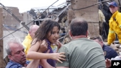 Un enfant est retiré des décombres de l'école primaire de Plaza Towers à Moore, Oklahoma, lundi 20 mai 2013.