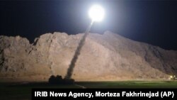 FILE - A missile is fired from city of Kermanshah, in western Iran, targeting the Islamic State group in Syria, June 19, 2017. Syrian government and allied troops have inserted themselves into the battle against IS militants by capturing key areas on the on the flanks of the coalition-led battle to seize Raqqa. 
