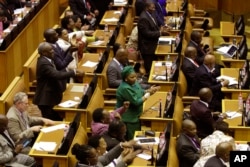 FILE - Members of the ruling African National Congress applaud as the results are read of a no-confidence vote by MP's in parliament in Cape Town South Africa, Aug. 8, 2017.