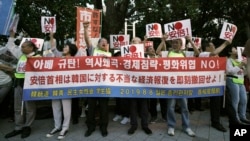 Protesters rally outside Japanese Prime Minister Shinzo Abe's residence in Tokyo Aug. 8, 2019 to urge the government to reverse the recent downgrading of South Korea's trade status and to apologize for wartime atrocities. (AP Photo/Eugene Hoshiko)