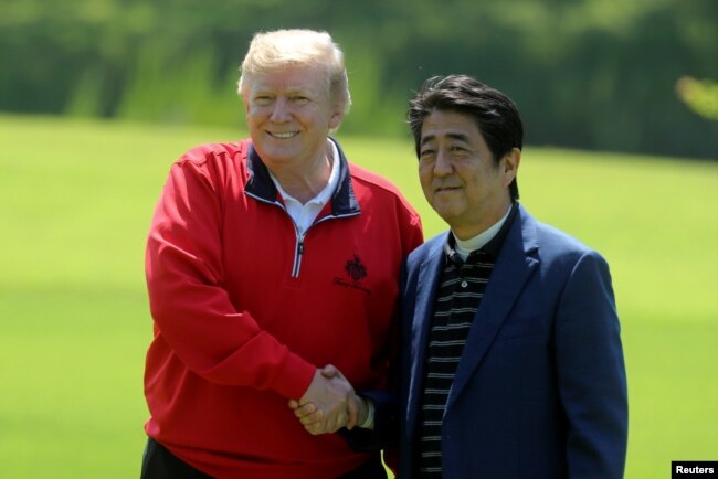 El primer ministro de Japón, Shinzo Abe, saluda al presidente de EE.UU. Donald Trump a su llegada al Mobara Country Club, en Mobara, prefectura de Chiba, en Japón. Mayo 26 de 2019.