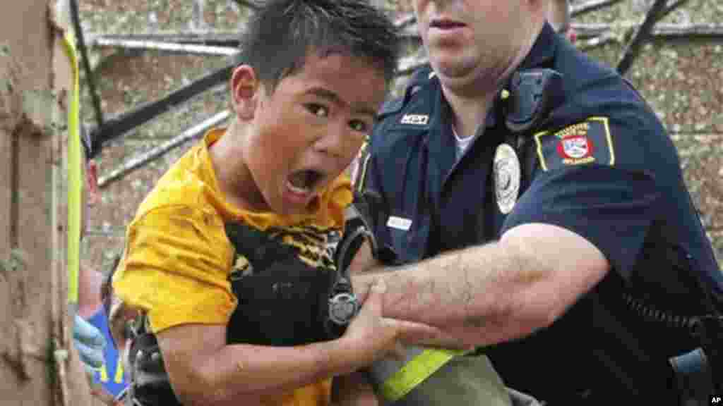 A boy is pulled from beneath a collapsed wall at the Plaza Towers Elementary School following a tornado in Moore, Okla., Monday, May 20, 2013.