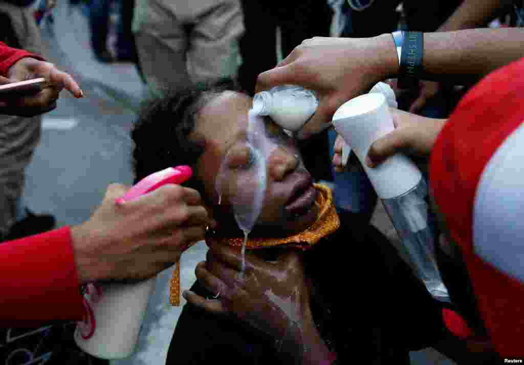 A woman affected by pepper spray is helped by others during a protest at Lafayette Park near the White House in Washington, May 31, 2020, following the death of George Floyd while being held by police in Minneapolis, Minnesota.&nbsp;