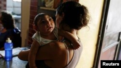 FILE - Ericka Torres holds her 3-month-old son, Jesus, who was born with microcephaly, at their home in Guarenas, Venezuela, Oct. 5, 2016. 