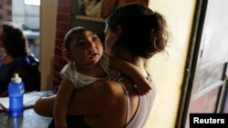FILE - Ericka Torres holds her 3-month-old son, Jesus, who was born with microcephaly, at their home in Guarenas, Venezuela, Oct. 5, 2016. 