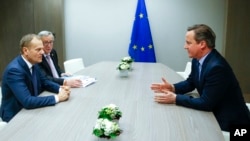 Presiden Dewan Eropa Donald Tusk (kiri) dan Presiden Komisi Eropa Jean-Claude Juncker, berbicara dengan PM Inggris David Cameron (kanan) pada KTT pemimpin Uni Eropa di Brussels, 19 Februari lalu.