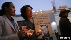 Members of the Australian Tibetan community stand together as they hold placards during a candlelight vigil for the Chinese Nobel Peace Prize-winning dissident Liu Xiaobo outside the Chinese embassy in Sydney, Australia, July 12, 2017.