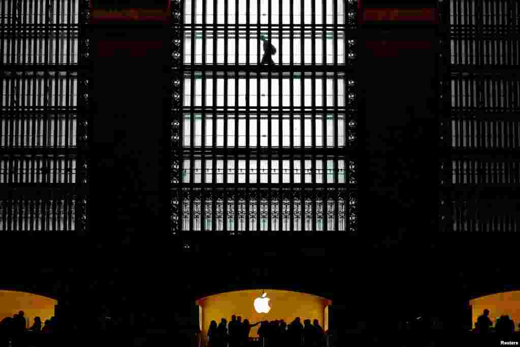 Customers walk past an Apple logo inside of an Apple store at Grand Central Station in New York, Aug. 1, 2018.