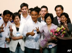 FILE - Former Hong Kong Secretary of Security Regina Ip, second from right in front, and Michael Tien, third from right in front, from the New People's Party celebrate after winning seats on the Legislative Council in Hong Kong, Sept. 10, 2012.