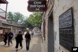 Pengunjung berjalan melewati Casa Rodriguez, salah satu bangunan tertua di St. Augustine.