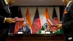Afghanistan Foreign Minister Salahuddin Rabbani, sitting left, and Indian External Affairs Minister Sushma Swaraj, sitting right, applaud during the exchange of agreements in New Delhi, India, Sept. 11, 2017. 