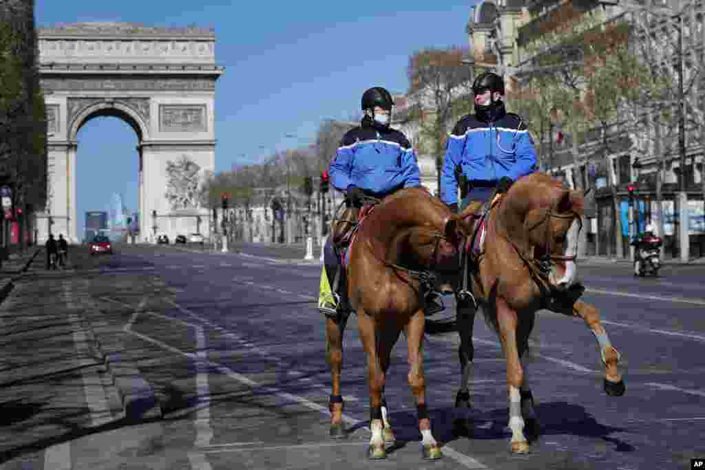 گشت دو پلیس اسب&zwnj;سوار در خیابان شانزه&zwnj;الیزه پاریس که در شیوع ویروس کرونا خالی و خلوت شده است.